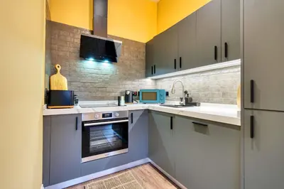a kitchen with a sink and a stove at Stunning Central Station 1 Bed Apartment A7 in Glasgow