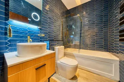 a blue tiled bathroom with a toilet and a sink at Lovely Central Station 1 Bed Apartment B10 in Glasgow