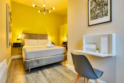 a small bedroom with a bed and a chair at Smart Central Station 1 Bed Apartment B11 in Glasgow