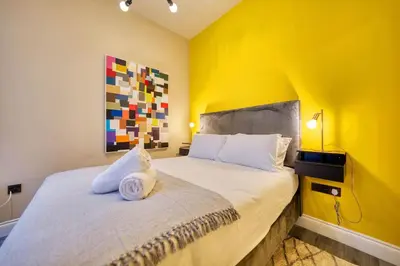 a bedroom with a bed with a yellow wall at Smart Central Station 1 Bed Apartment B11 in Glasgow