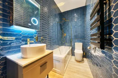 a blue tiled bathroom with a sink and a toilet at Smart Central Station 1 Bed Apartment B11 in Glasgow