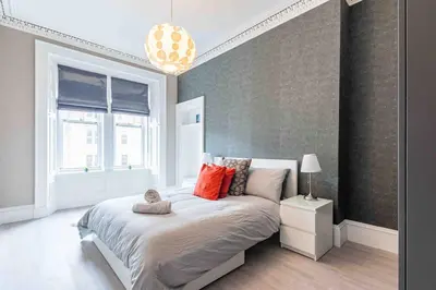 a bedroom with a large bed and a window at Spacious 3 bed home in Marchmont in Edinburgh