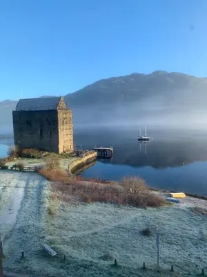an old building in the middle of a body of water at Tower View Apartment in Carrick