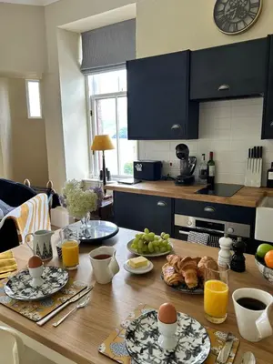 a kitchen with a wooden table with food on it at Tower View Apartment in Carrick