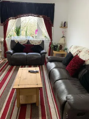 a living room with a leather couch and a coffee table at Little Universe in Edinburgh