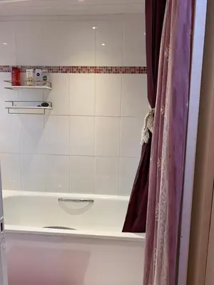 a bathroom with a bath tub with a shower curtain at Little Universe in Edinburgh