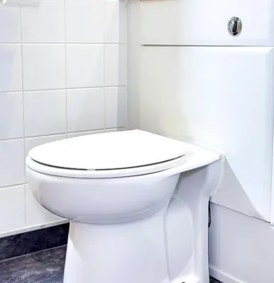 a white toilet in a white tiled bathroom at Glasgow City Centre Stylish Flat in Glasgow