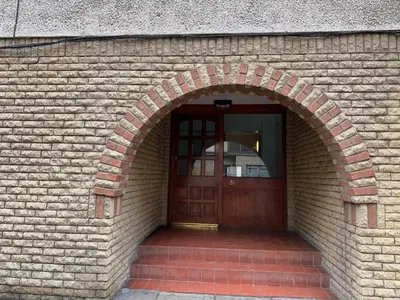 an entrance to a brick building with a wooden door at Cozy Central Flat near Edinburgh Castle and with Free Private Parking in Edinburgh