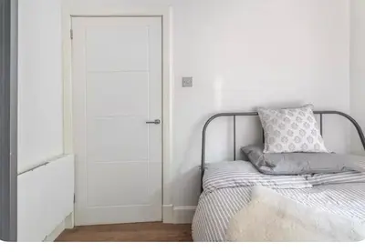 a bedroom with a bed and a white door at The Gardners apartment in City centre with parking in Edinburgh