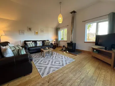 a living room with a couch and a tv at Callanish Bothy in Benderloch