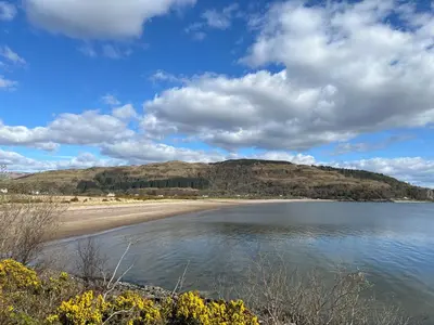 a view of a beach with a hill in the background at Callanish Bothy in Benderloch
