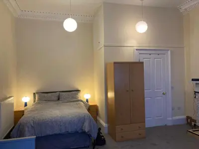 a bedroom with a bed and two lights above it at Gilmore Flat in Edinburgh