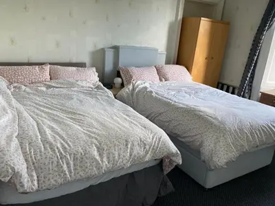 a bedroom with two beds with pink and white sheets at Gilmore Flat in Edinburgh
