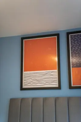 a wall with two framed pictures on top of a couch at Skye House in Grangemouth