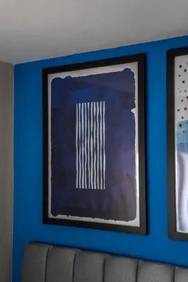 a blue wall with a picture on top of a couch at Skye House in Grangemouth