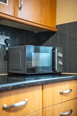 a microwave oven sitting on top of a kitchen counter at Skye House in Grangemouth