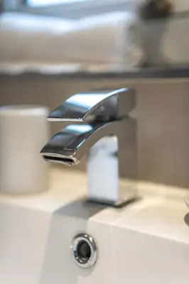 a bathroom sink with a faucet on a counter at Skye House in Grangemouth