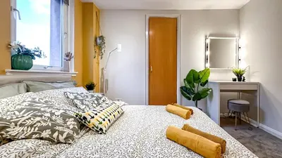 a bedroom with a bed with pillows and a mirror at Sunny day new flat with 5 beds in Clydebank