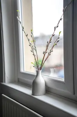 a white vase sitting on a window sill with flowers at Caledonia Apartment in South Cobbinshaw
