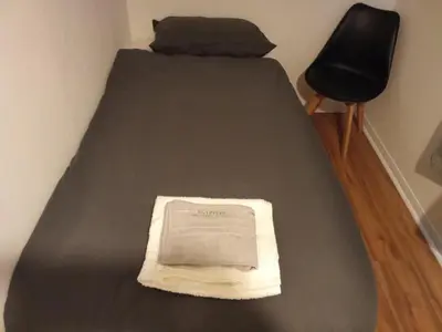 a bed with a book on it with a chair at Charming home away from home! in Edinburgh
