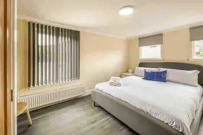 a bedroom with a large bed and a window at Barra Cottage in Ballachulish