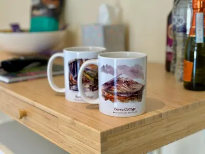 two coffee mugs sitting on top of a wooden counter at Barra Cottage in Ballachulish