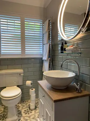 a bathroom with a sink and a toilet and a mirror at Tumpseys Hideaway with Hot Tub & Sunset Loch Views, Glencoe Near Fort William in Ballachulish