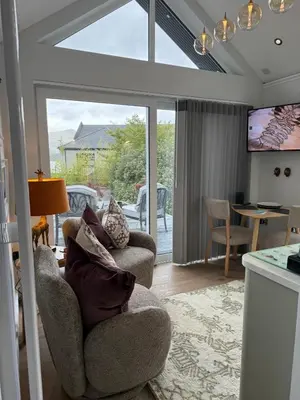 a living room with two chairs and a television at Tumpseys Hideaway with Hot Tub & Sunset Loch Views, Glencoe Near Fort William in Ballachulish