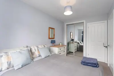 a bedroom with a large bed and a mirror at Modern flat near Murrayfield stadium, sleeps 4 in Edinburgh