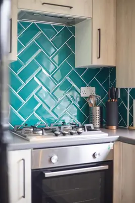 a kitchen with a stove with a green tiled wall at Modern flat near Murrayfield stadium, sleeps 4 in Edinburgh