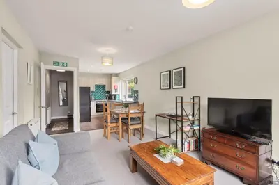 a living room with a couch and a tv and a table at Modern flat near Murrayfield stadium, sleeps 4 in Edinburgh