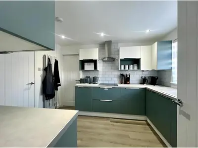 a kitchen with green cabinets and white appliances at Dunmuir House 4 Bedroom 2 bathroom House & Garden in Denny in Falkirk