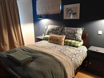 a bedroom with a bed with pillows on it at Wee Blue Hoose in Dalmally