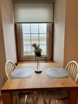 a dining room table with a vase of flowers on it at Harbour View Irvine in Irvine