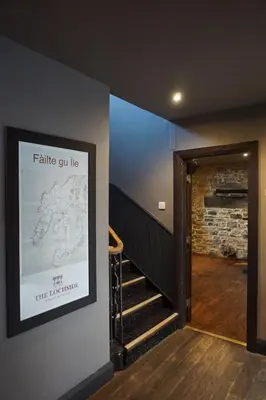 a stairway with a sign that saysfalle gun lie at Lochside Hotel in Bowmore