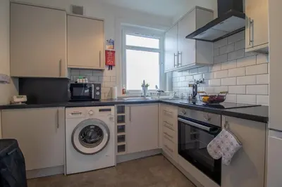 a kitchen with a washer and a washing machine at Kerr Apartment-Spacious 4-Bed Flat in Hamilton, Close to Glasgow in Cadzow