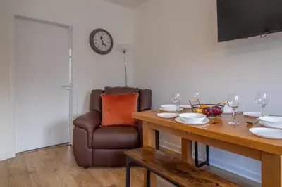 a dining room with a table and a chair at Kerr Apartment-Spacious 4-Bed Flat in Hamilton, Close to Glasgow in Cadzow