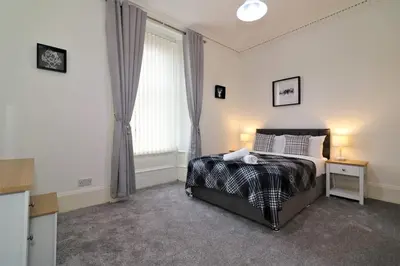 a bedroom with a bed and a desk and a window at 10 Bedrooms Pool Table Garden Piano in Glasgow