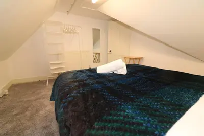 a bedroom with a bed with a pillow on it at 10 Bedrooms Pool Table Garden Piano in Glasgow