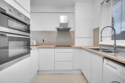 a kitchen with white cabinets and a sink at 3 Bedrooms Homely House in Motherwell Sleeps 8 comfortably with 6 double beds Near Glasgow Edinburgh Free Private Parking Business Travellers Contractors Holiday Goers Near all Major transport links in Carfin