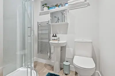 a bathroom with a toilet and a sink and a shower at The Post Office in Torphichen