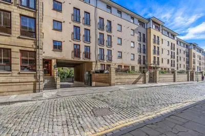 an empty street in front of a large building at Modern 2 bedroom apartment in City Centre in Edinburgh