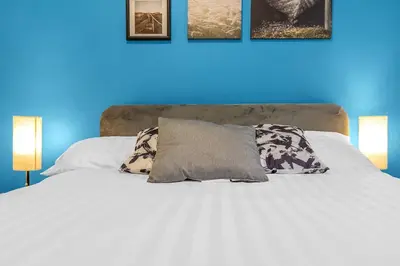 a white bed with two pillows and a blue wall at Modern 2 bedroom apartment in City Centre in Edinburgh