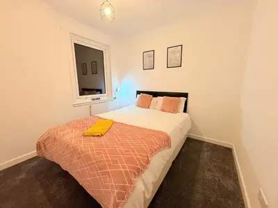 a bedroom with a bed with a yellow towel on it at RF-Entire House-Central Scotland-Falkirk, Self-Check-in , Pet-friendly and with Parking in Falkirk