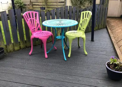 three chairs and a table on a patio at Tin Lid Cottage - cosy ground floor flat in Banton