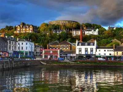 a town next to a body of water with houses at 5 Oban in Oban