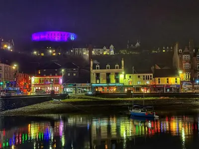 a city lit up at night with a harbor at 5 Oban in Oban