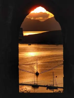 a sunset over the ocean with boats in the water at 5 Oban in Oban