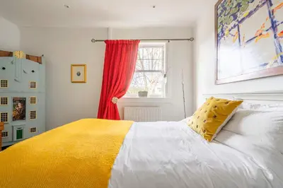 a bedroom with a white bed with a yellow blanket at Peace in the City in Edinburgh