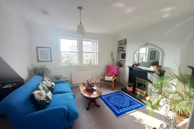 a living room with a blue couch and a fireplace at Peace in the City in Edinburgh